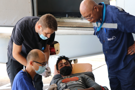 Doctors Jesh and Joel with MAF staff in hangar