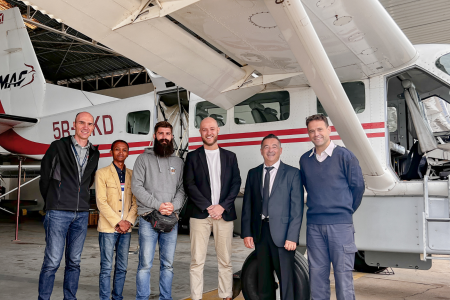 Mission 3:16 team with Michael Jurgensen and Patrick Keller in front of MAF plane in hangar